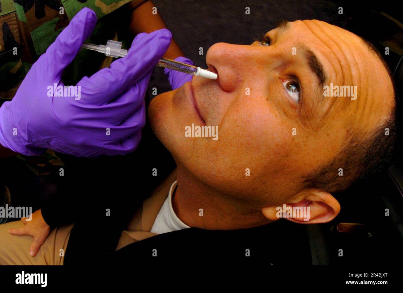 US Navy  Senior Chief Navy Counselor assigned to Commander Naval Recruiting Command, receives his annual Influenza vaccine in the form of a nasal mist. Stock Photo