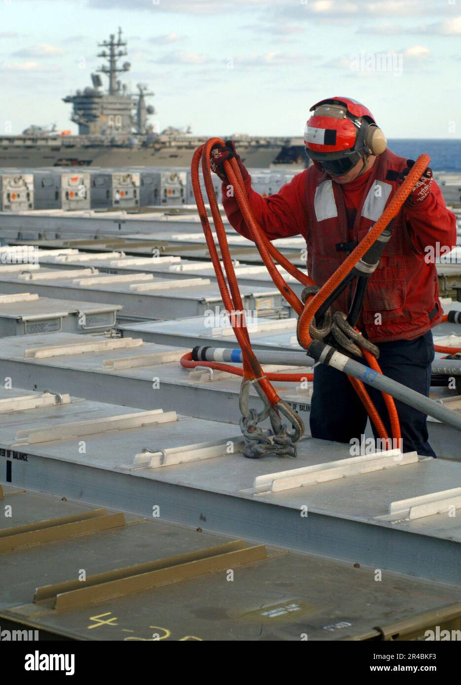 US Navy  A Sailor assigned to Weapons Department attaches a replenishment pennant to an ordnance storage case on the flight deck of the Nimitz-class aircraft carrier USS Harry S. Truman (CVN 75). Stock Photo