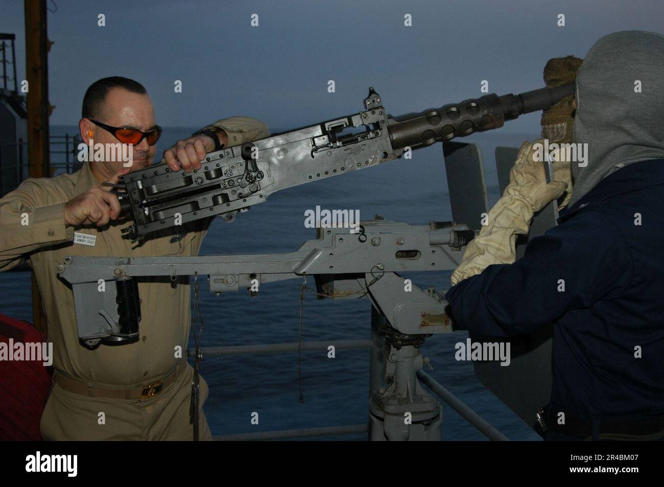 US Navy Chief Aviation Ordnanceman assists a Sailor from the weapons ...