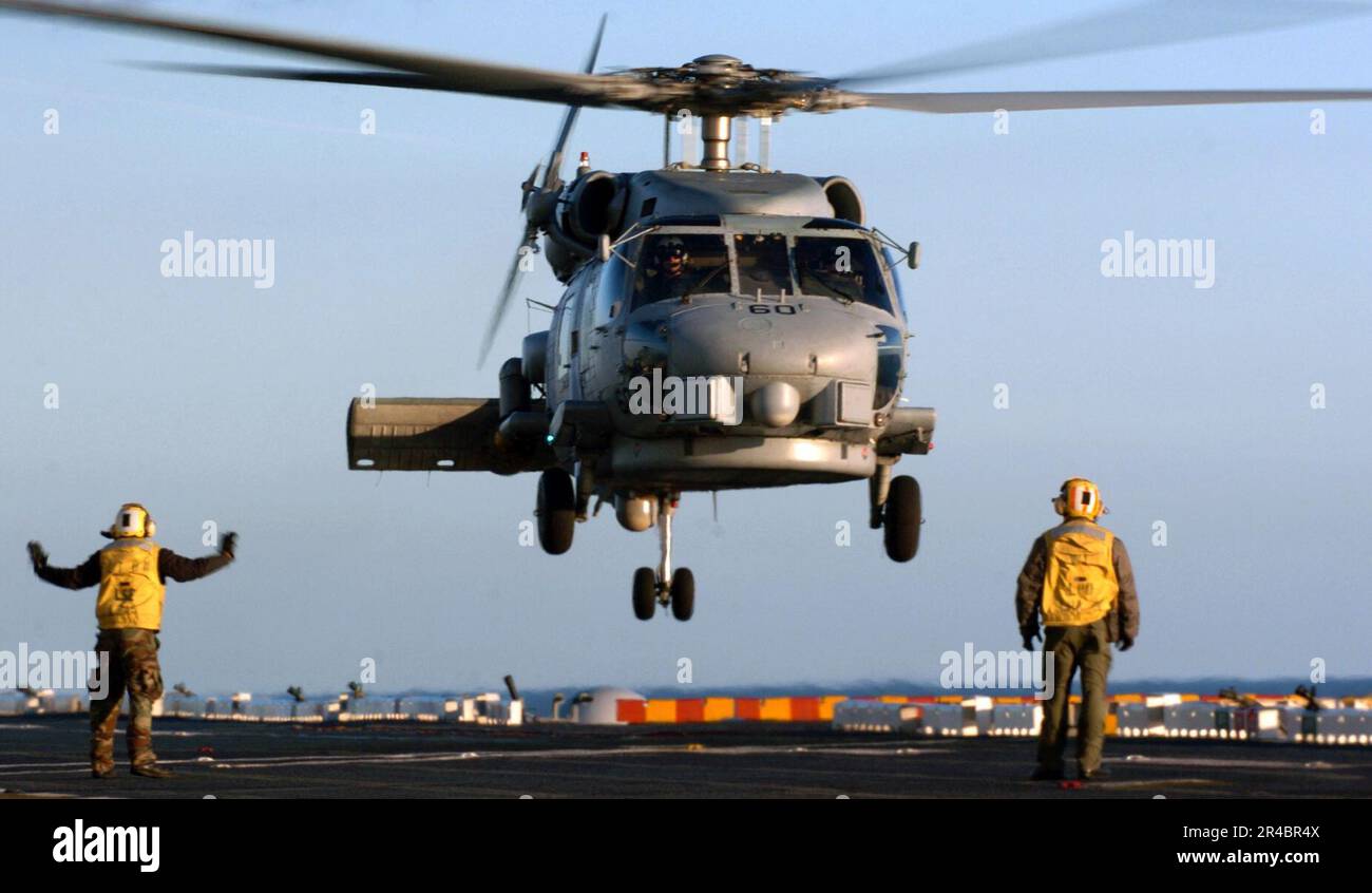 US Navy Aviation Boatswain's Mates direct an SH-60B Seahawk helicopter ...