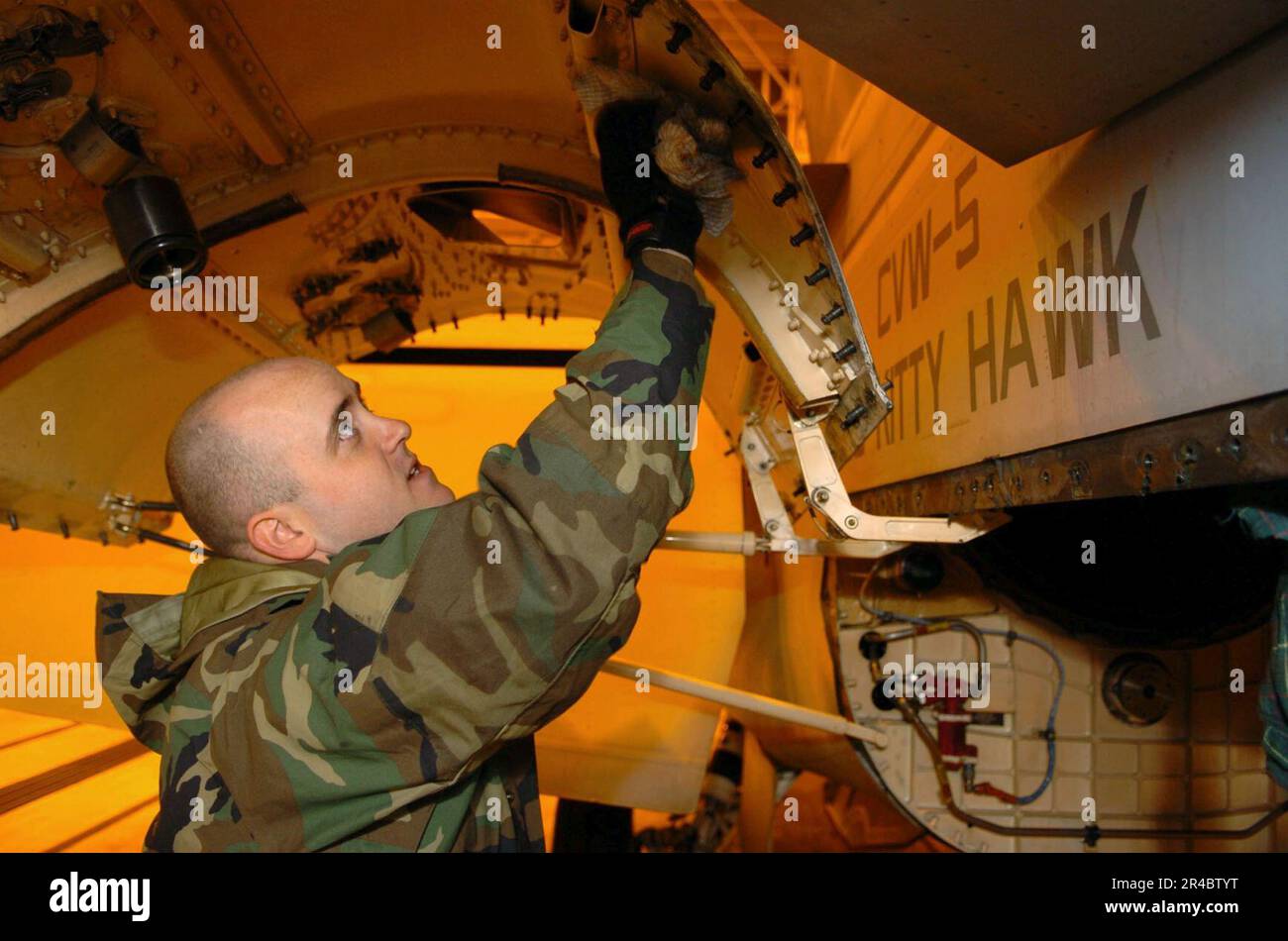 US Navy Aviation Machinist Mate 3rd Class cleans a engine bay door on