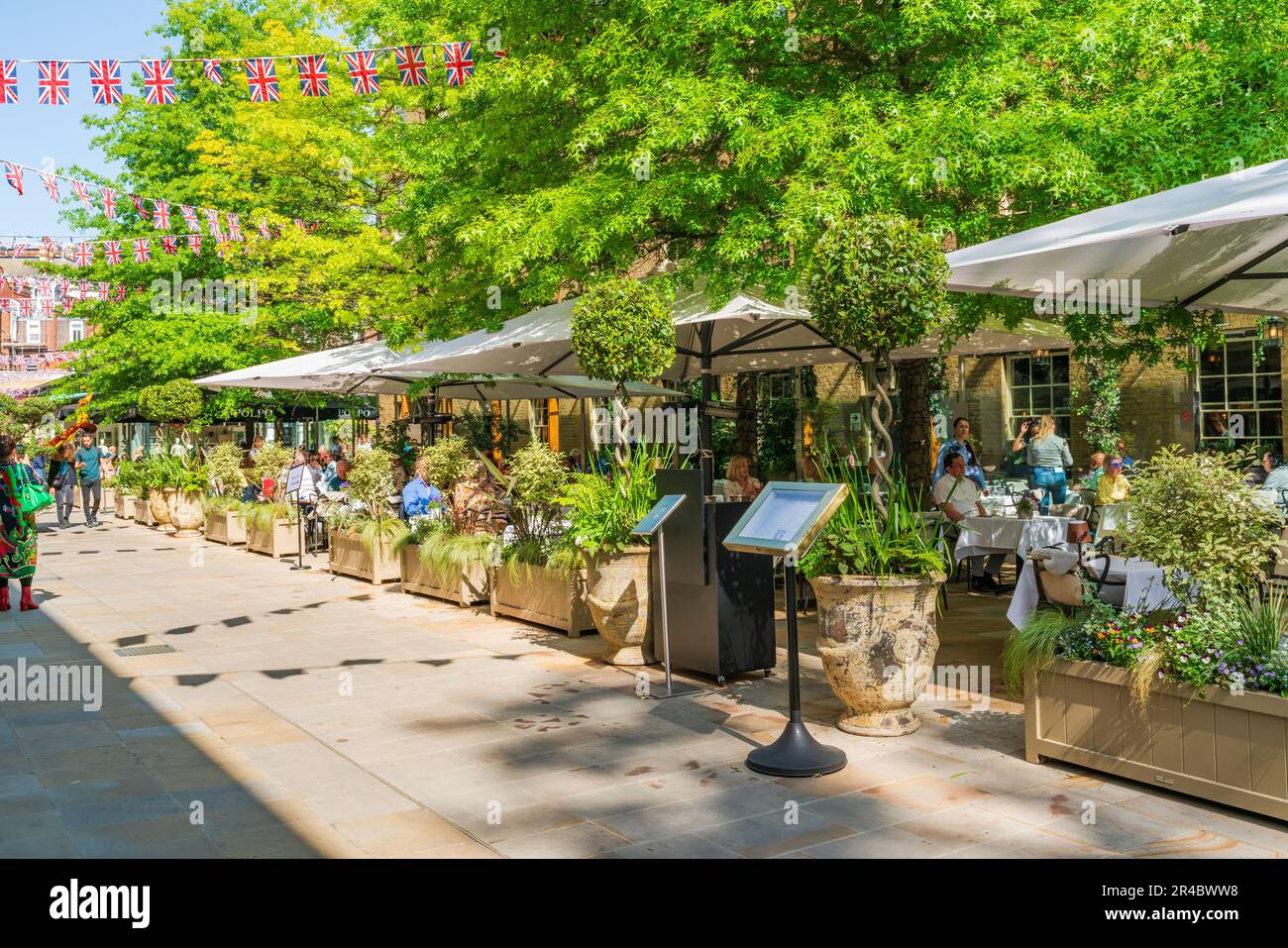 LONDON, UK - MAY 24, 2023: People enjoy sunny spring day in Chelsea, an affluent area known for the smart boutiques and high-end restaurants Stock Photo