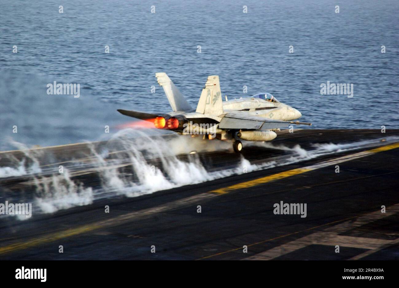 US Navy  An F-A-18C Hornet assigned to the Golden Warriors of Strike Fighter Squadron Eight Seven (VFA-87) launches from the flight deck aboard the Nimitz-class aircraft carrier USS Theodore Roosevelt (CVN 71). Stock Photo