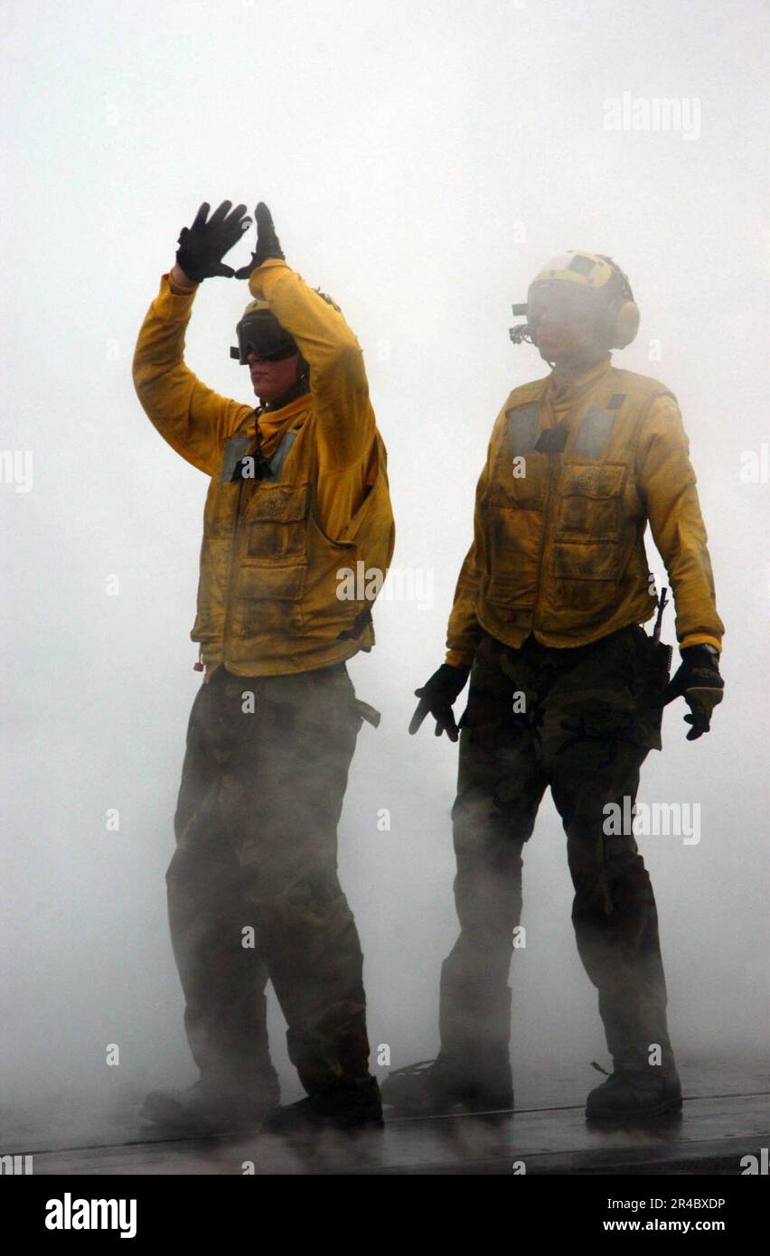 US Navy An Aviation Boatswain's Mate Handler directs an aircraft onto a