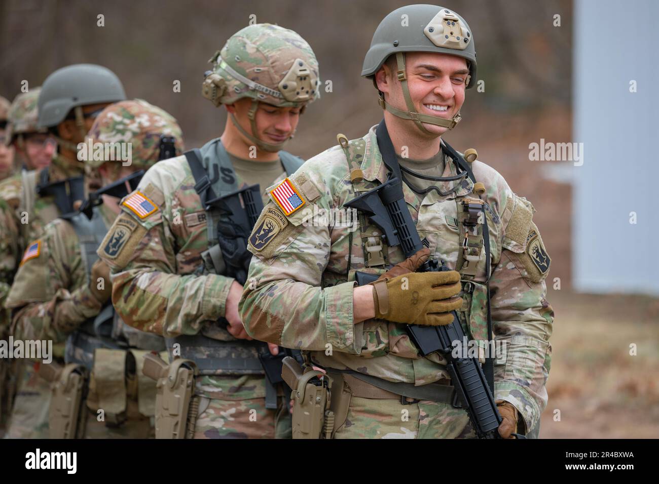 U.S. Army Staff Sgt. Conrad Sheldon, an infantryman assigned to the 1st Battalion, 102nd Infantry Regiment, Connecticut Army National Guard, smiles as he waits in line with his fellow competitors prior to moving out to zero his M4A1 carbine before beginning the stress shoot portion of the 2023 Connecticut Army National Guard Best Warrior Competition at the Connecticut Army National Guard Training Center East Haven Rifle Range, East Haven, Connecticut, March 24, 2023. The competition drew soldiers from across the Connecticut Army National Guard and over the course of three days these competitor Stock Photo