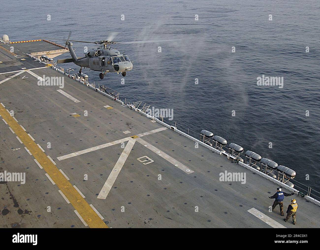US Navy An MH-60S Seahawk helicopter is directed onto the flight deck ...