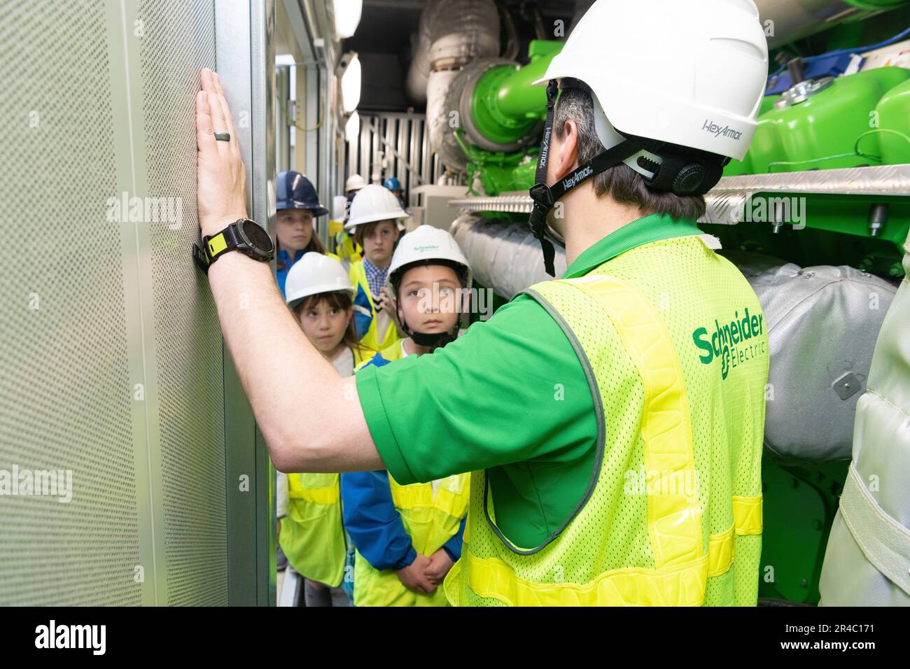 Nick Canton, Schneider Electric energy manager, gives participants a tour of generator sets for the new Combined Heating and Power (CHP) plant at Yokota Air Base, Japan, March 24, 2023. This CHP plant is part of an Energy Savings Performance Contract (ESPC) which began active construction in 2020.  An ESPC is a partnership between federal agencies and energy service companies that provides energy savings, resiliency, and facility improvements with no up-front capital costs to the government. Stock Photo