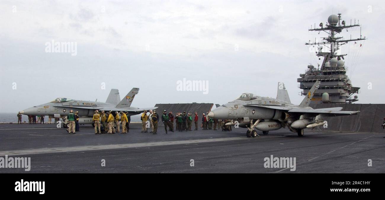 US Navy  F-A-18C Hornets assigned to the Golden Warriors of Strike Fighter Squadron Eight Seven (VFA-87) prepare to launch from the flight deck of the Nimitz-class aircraft carrier USS Theodore Roosevelt (CVN. Stock Photo