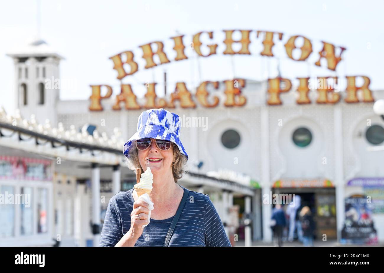 Brighton UK 27th May 2023 - Time for an ice cream on Brighton Palace Pier as visitors enjoy the bank holiday weekend sunshine which is forecast for most of the UK over the next few days : Credit Simon Dack / Alamy Live News Stock Photo