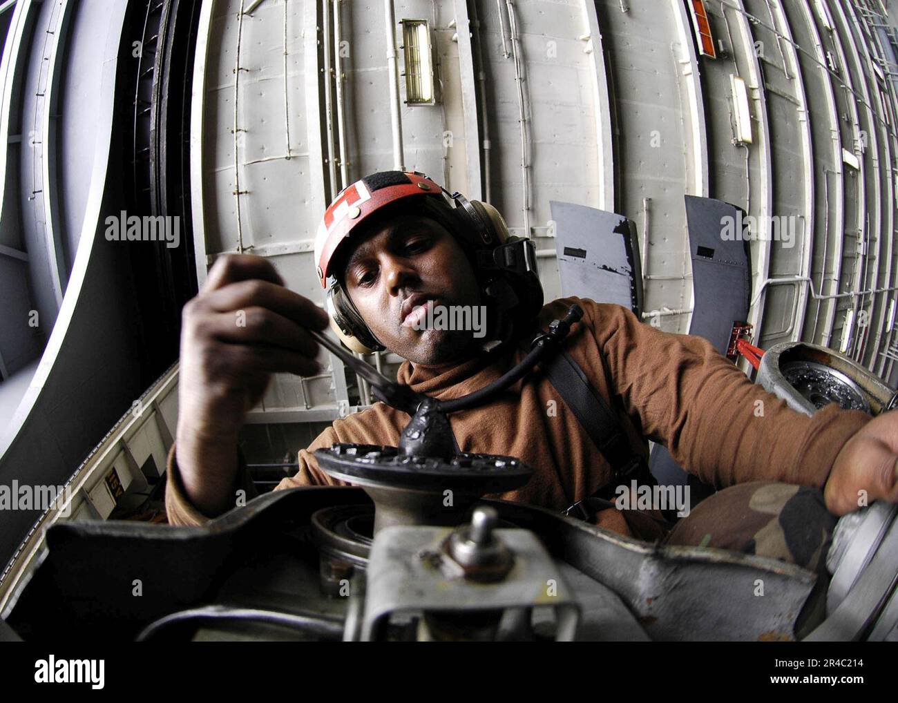 US Navy Aviation Electronics Technician 3rd Class applies grease to the