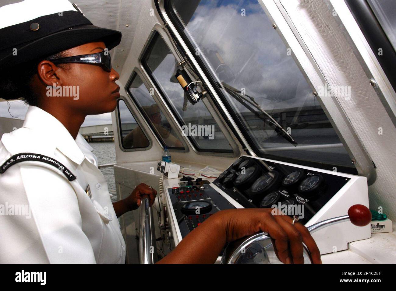 US Navy Boatswain's Mate 2nd Class pilots a tour boat from the USS Arizona Memorial Detachment