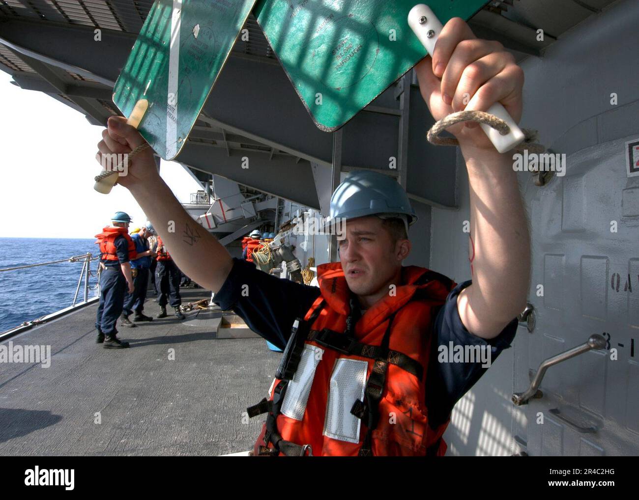 US Navy Boatswain's Mate 3rd Class practices signaling aboard the ...