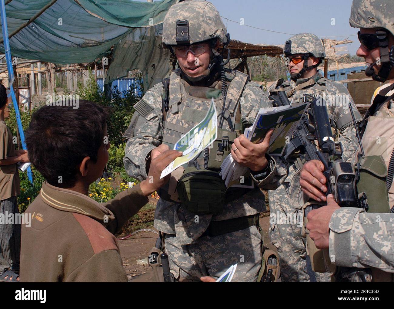 US Navy  U.S. Army soldiers hand out maps and information to the residents of Tarmiya, about safe routes they have to take entering or leaving their town because of ongoing counter-insurgency operations in the. Stock Photo