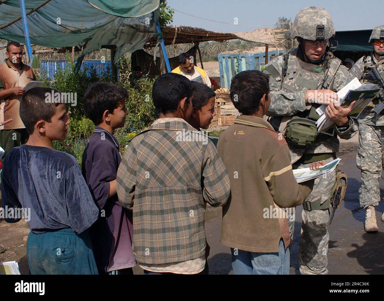 US Navy  U.S. Army soldiers hand out maps and information to the residents of Tarmiya, about safe routes they have to take entering or leaving their town, because of ongoing counter-insurgency operations in th. Stock Photo
