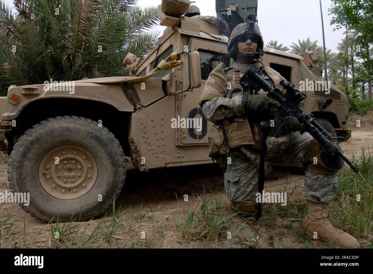 US Navy  U.S. Army Spc. stands perimeter security in front of an M1114 HMMWV (Humvee) near the town of Tarmiya, Iraq during counter-insurgency operations. Stock Photo