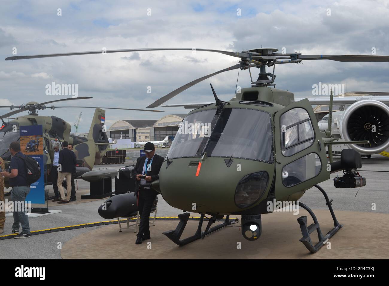 A large, military-style helicopter is parked on the tarmac of an airport Stock Photo