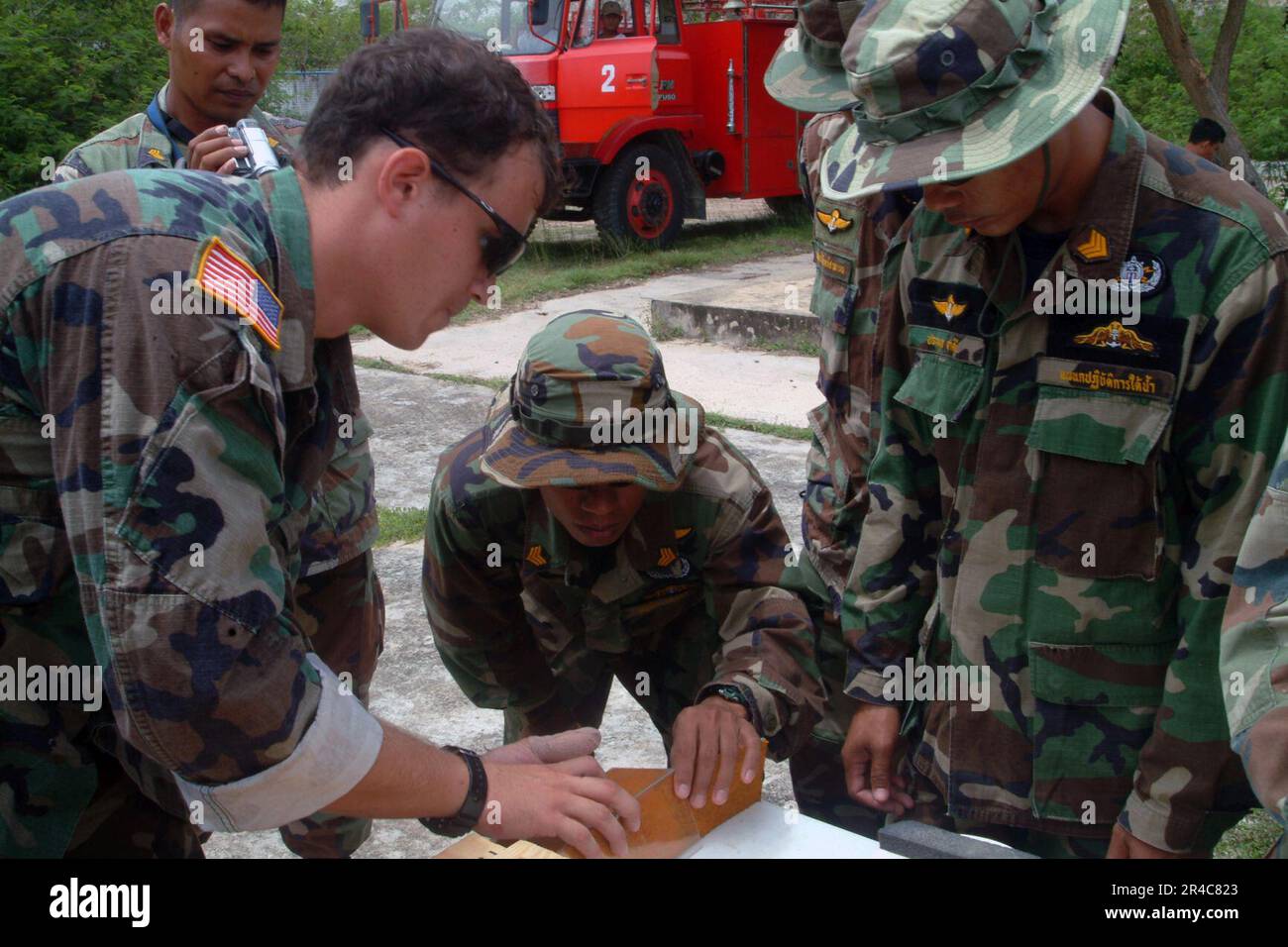 US Navy Electronics Technician 1st Class works with Royal Thai Navy (RTN) EOD personnel while preparing an explosive charge which will be used to demolish a vehicle transported from the United Stock Photo