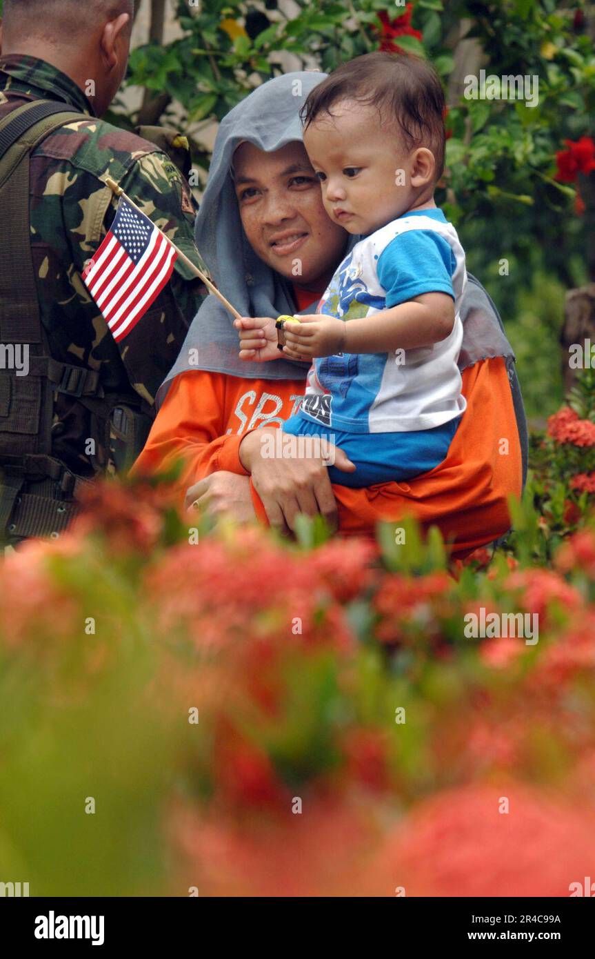 US Navy  A local Filipino mother and her son receive care from a Medical Civil Action Program (MEDCAP) located on Basilan Island. Stock Photo