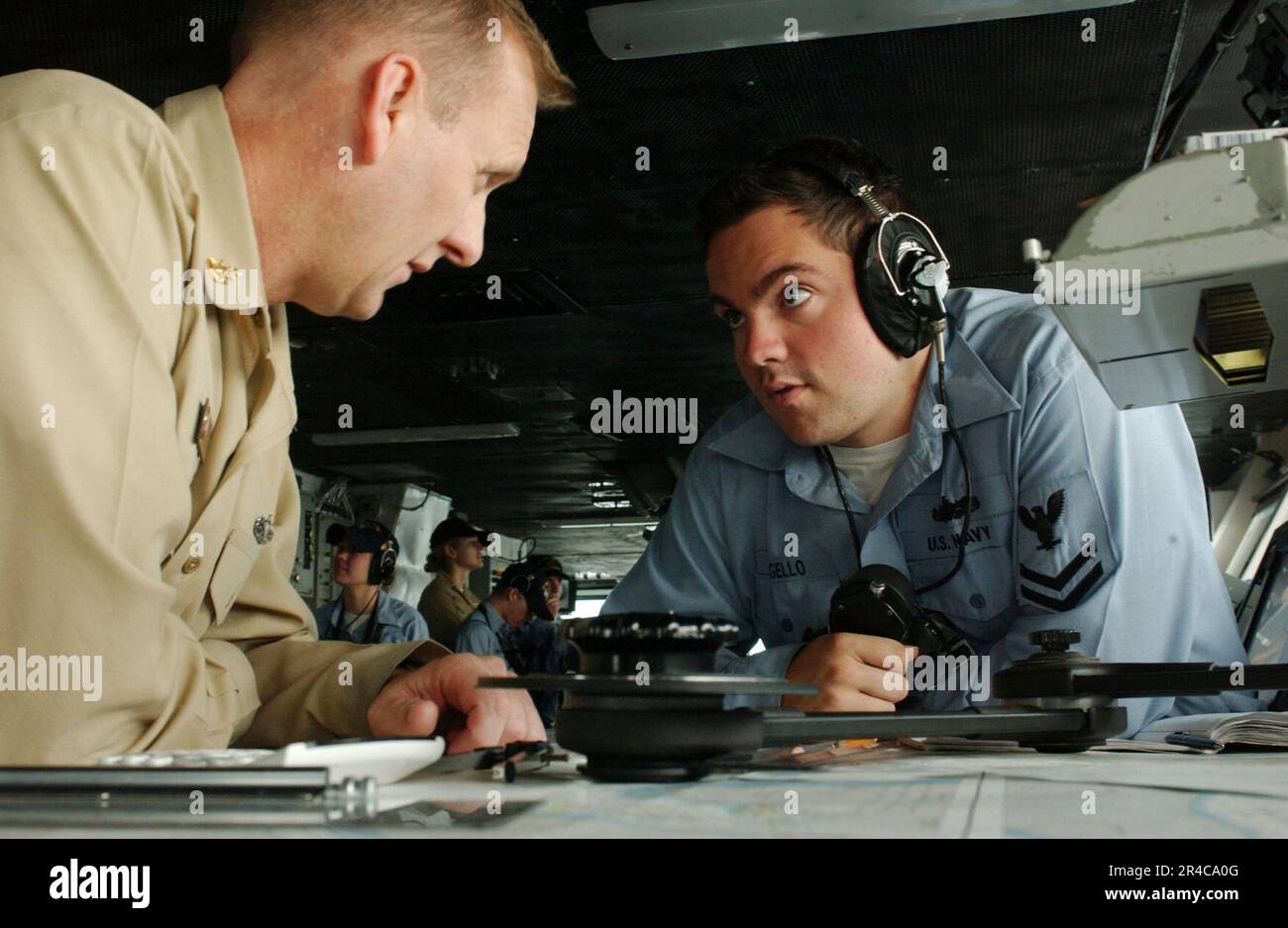 US Navy Quartermaster 2nd Class receives training on navigation charts from Senior Chief
