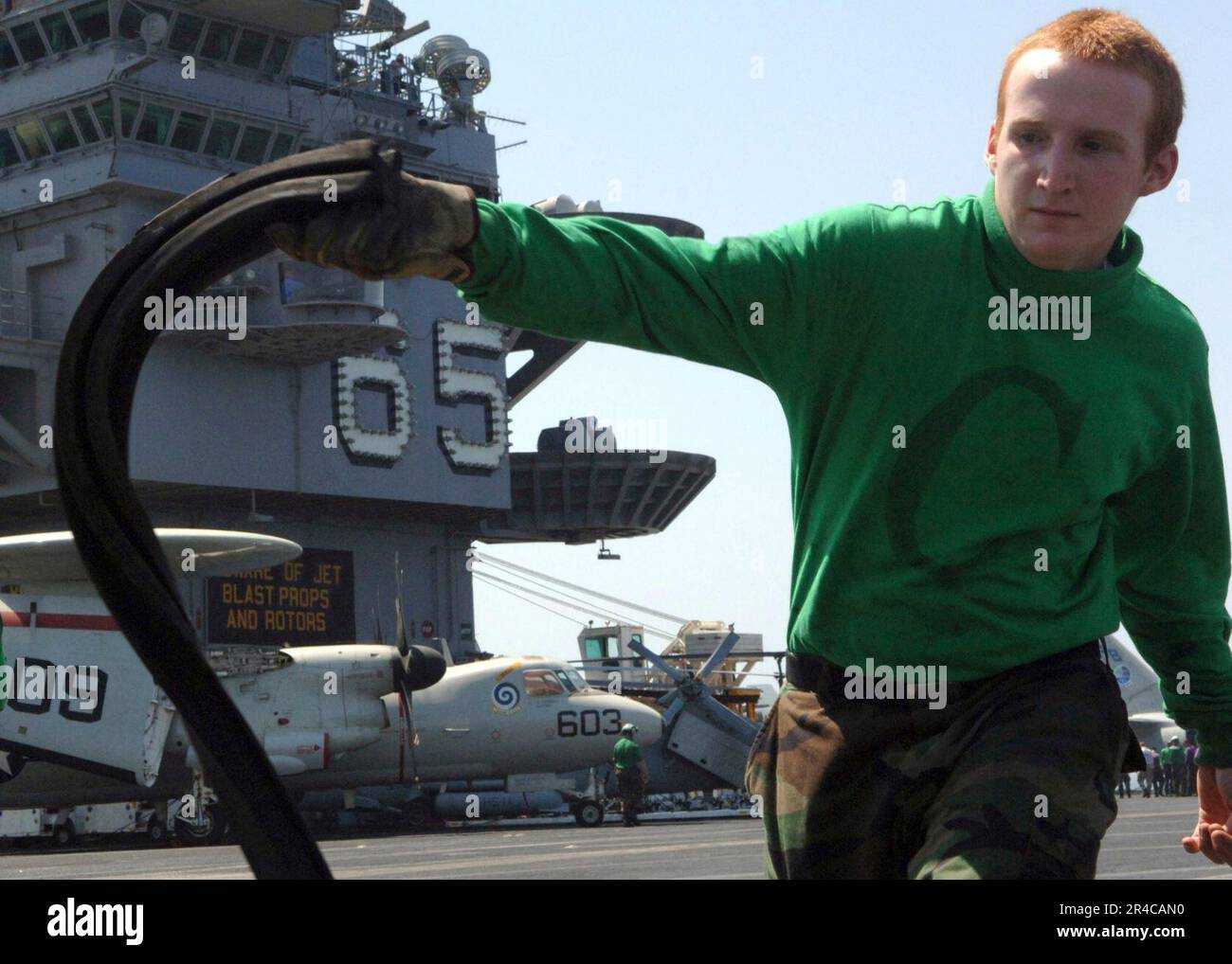 US Navy Airman unwraps the waist catapults on the flight deck of the ...