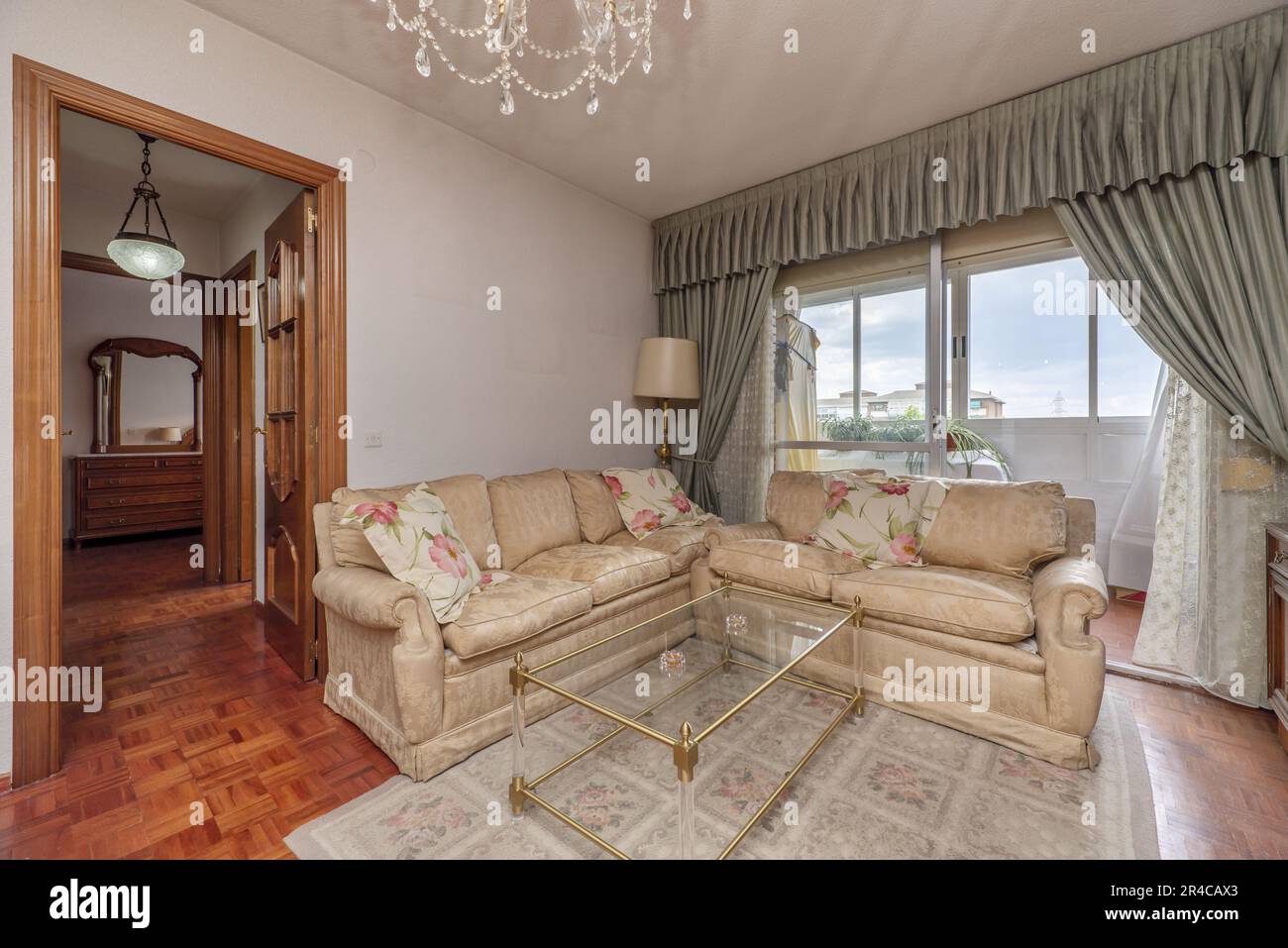 A set of creamcolored fabric sofas with a rug and a bay window with