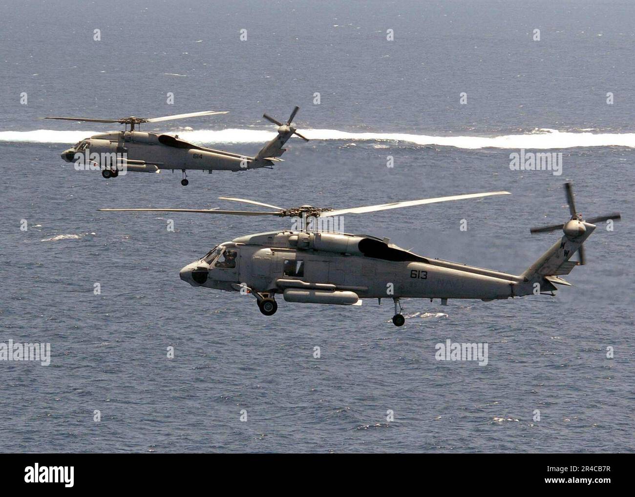 US Navy  Two SH-60F Seahawks helicopters assigned to the Emerald Knights, of Helicopter Anti-Submarine Squadron Seven Five (HS-75) fly in formation. Stock Photo
