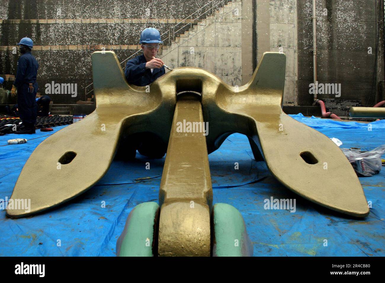 US Navy Boatswain's Mate 3rd Class paints one of the 9000 pound Navy