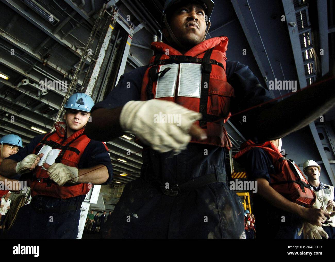 US Navy Boatswain's Mates heave a line during an underway replenishment