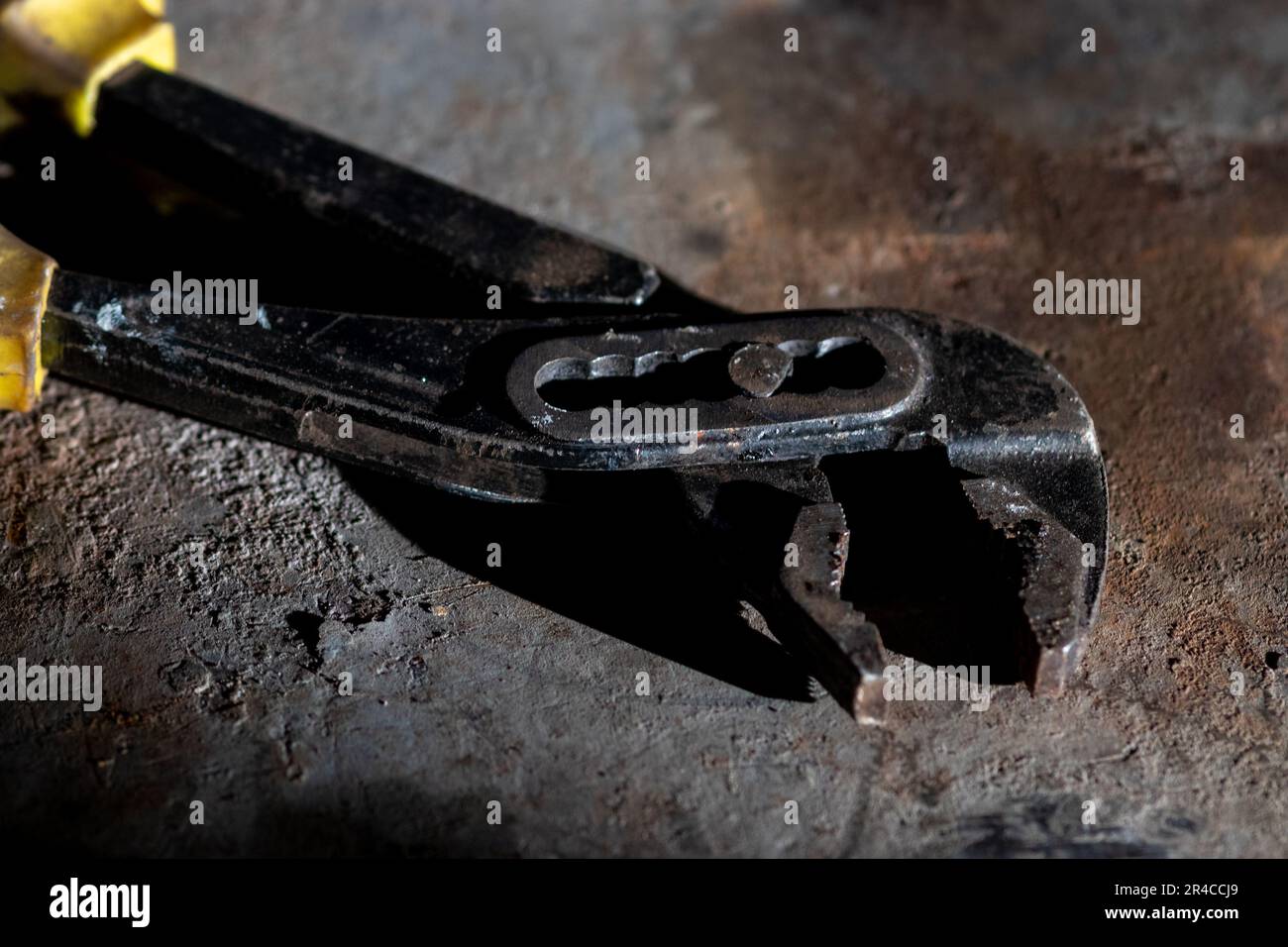 A vintage metallic tool resting on top of an antiquated metallic object Stock Photo