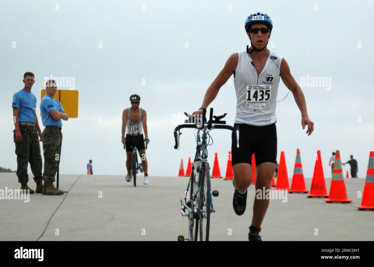 US Navy A cyclist hops off his bike to begin the run portion of the