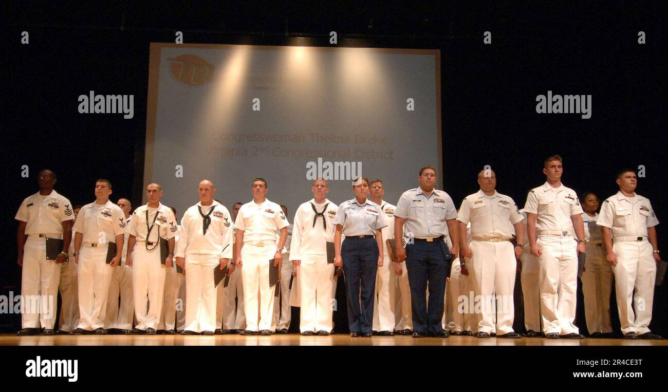 US Navy Sailors, Marines and Coast Guard personnel stand at attention