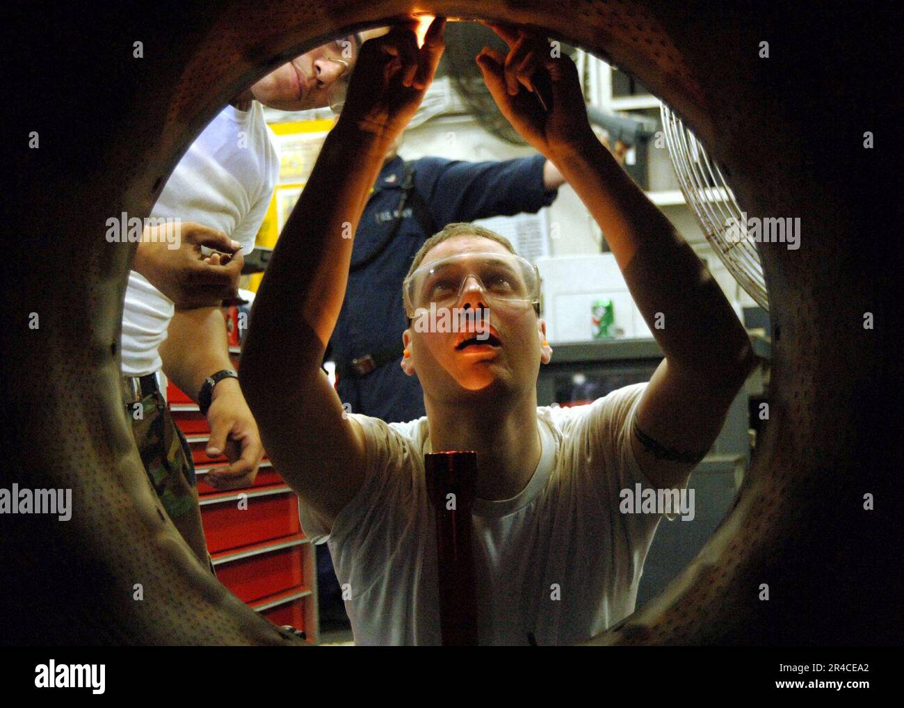 US Navy Aviation Machinist Mate 2nd Class installs an afterburner mixer