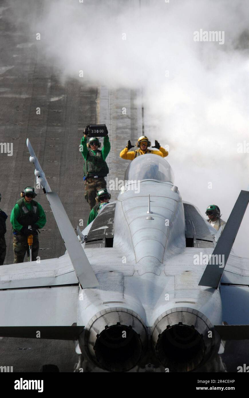 US Navy  An aircraft handler lines up an F-A-18C Hornet on the number-one catapult prior to take off during flight operations aboard the Nimitz-class aircraft carrier USS Ronald Reagan (CVN 76). Stock Photo