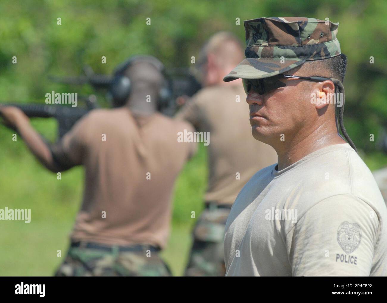 US Navy Petty Officer 1st Class observes Sailors during a M16A1 qualification at the Naval Base Guam gun range Stock Photo