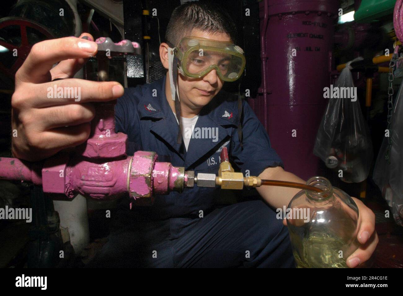 US Navy Aviation Boatswain's Mate Fuels 3rd Class takes a sample of JP