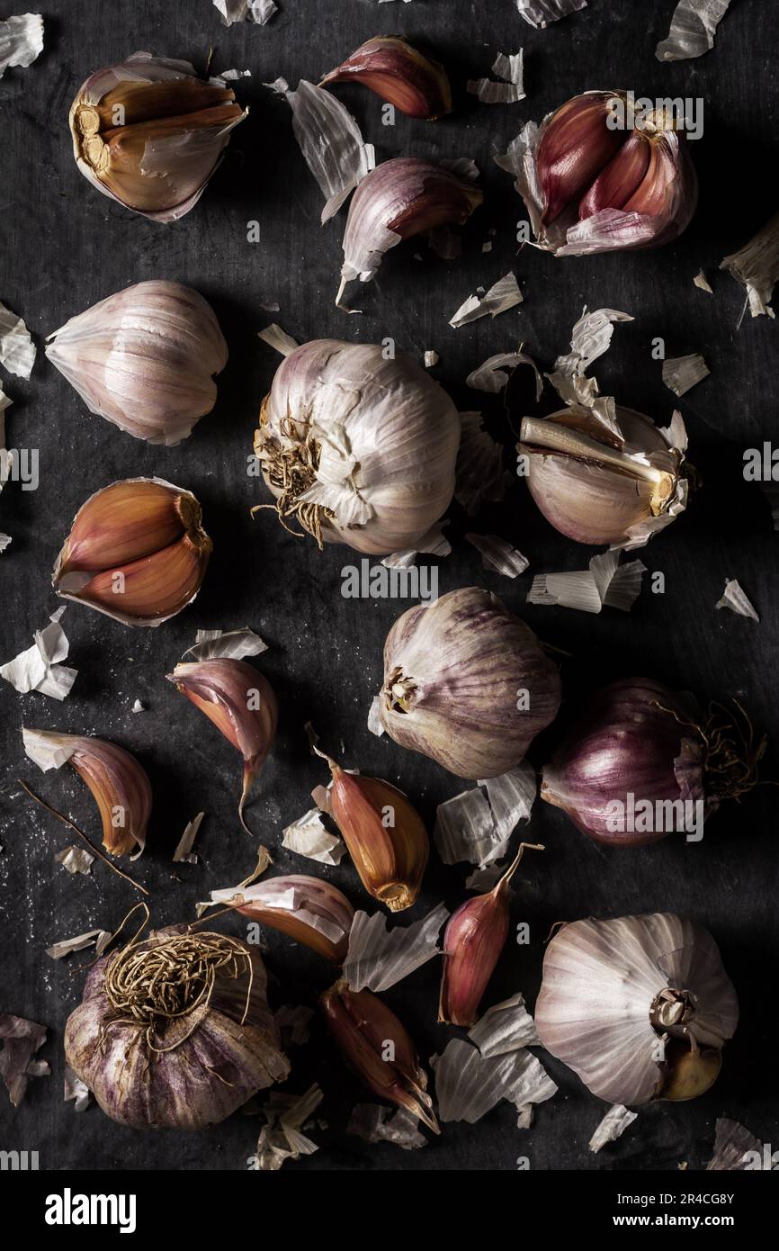Fresh garlic bulbs and cloves grouped on black background. Flat lay ...