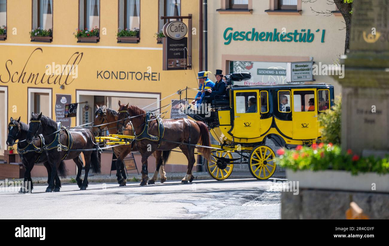 Oberwiesenthal, Germany. 27th May, 2023. Coachmen Anne and Christoph Kaufmann take the historic Oberwiesenthal stagecoach on its first ride since 2019 through Germany's highest town. After an extensive general refurbishment of the four-in-hand carriage with work on the frame, the paintwork, the upholstery and the braking system as well as the replacement of four harnesses of English tension, the carriage will now be used again for tourist purposes from May to October. Credit: Kristin Schmidt/dpa-Zentralbild/ZB/dpa/Alamy Live News Stock Photo