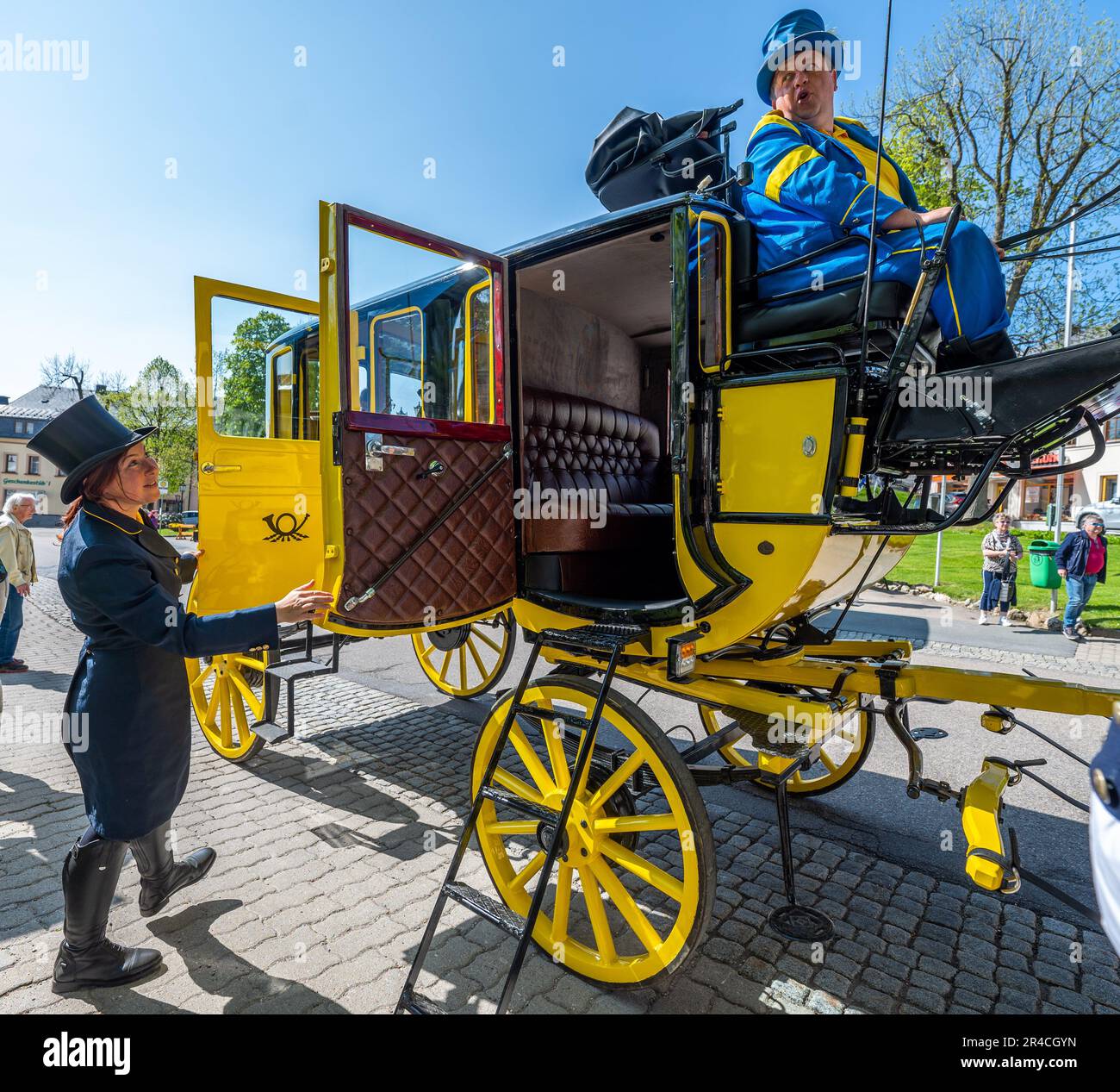 Oberwiesenthal, Germany. 27th May, 2023. The coachmen Anne and Christoph Kaufmann start with the historic stagecoach Oberwiesenthal on the market of the highest town in Germany for their first trip since 2019. After an extensive general renovation of the four-in-hand carriage with work on the frame, the paint, the upholstery and the brake system, as well as the replacement of four harnesses of English tension, the carriage is now used again for tourist purposes from May to October. Credit: Kristin Schmidt/dpa-Zentralbild/ZB/dpa/Alamy Live News Stock Photo