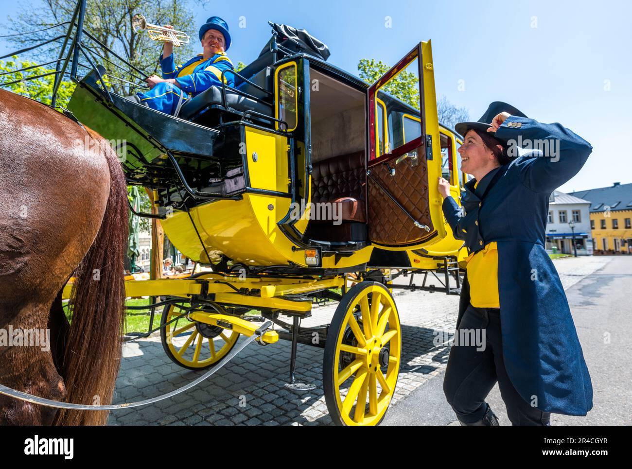 Oberwiesenthal, Germany. 27th May, 2023. The coachmen Anne and Christoph Kaufmann start with the historic stagecoach Oberwiesenthal on the market of the highest town in Germany for their first trip since 2019. After an extensive general renovation of the four-in-hand carriage with work on the frame, painting, upholstery and braking system, as well as the replacement of four harnesses of English tension, the carriage is now used again for tourist purposes from May to October. Credit: Kristin Schmidt/dpa-Zentralbild/ZB/dpa/Alamy Live News Stock Photo