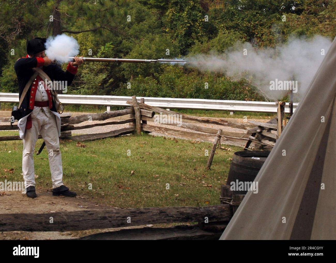 US Navy  Retired Chief Aviation Structural Mechanic a historical interpreter, fires a flintlock musket during a demonstration. Stock Photo