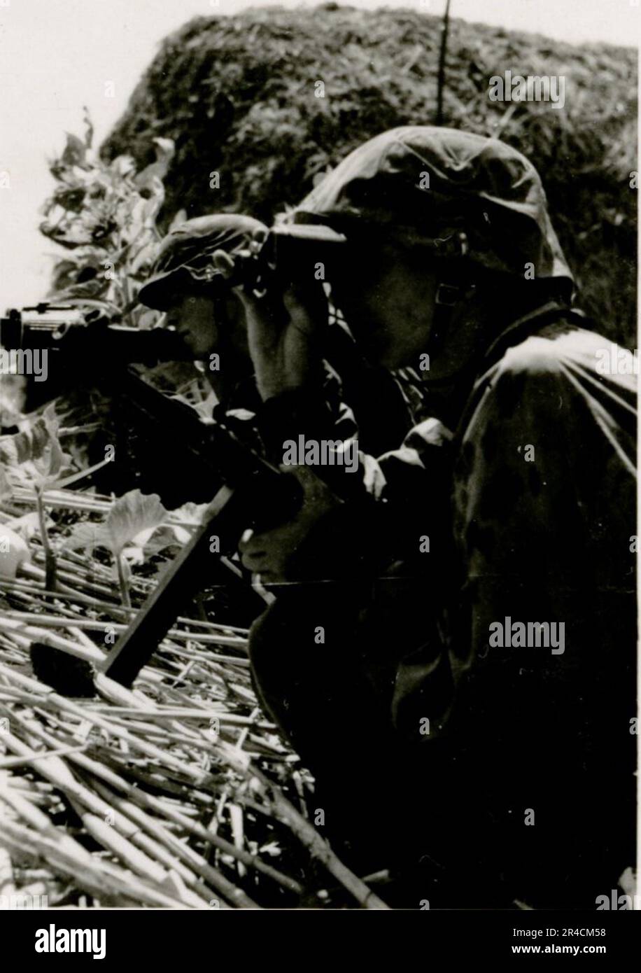 SS Photographer Willi Altstadt, Wiking Division, Russia 1942.  Rostov area village scenes, a Panzer III (with unit symbols) and panzer grenadiers on the steppe, combat scenes along a river, close-ups of infantry in the field with individual and crew-served weapons, a river crossing (assault and pontoon rafts), construction of a road block, Russian prisoners of war, SS-soldiers fishing and swimming, unit awards ceremony, observation post overlooking a river, and heavy artillery crew with howitzer. Images depicting the front-line activities of Waffen-SS units on the Western and Eastern Fronts, i Stock Photo