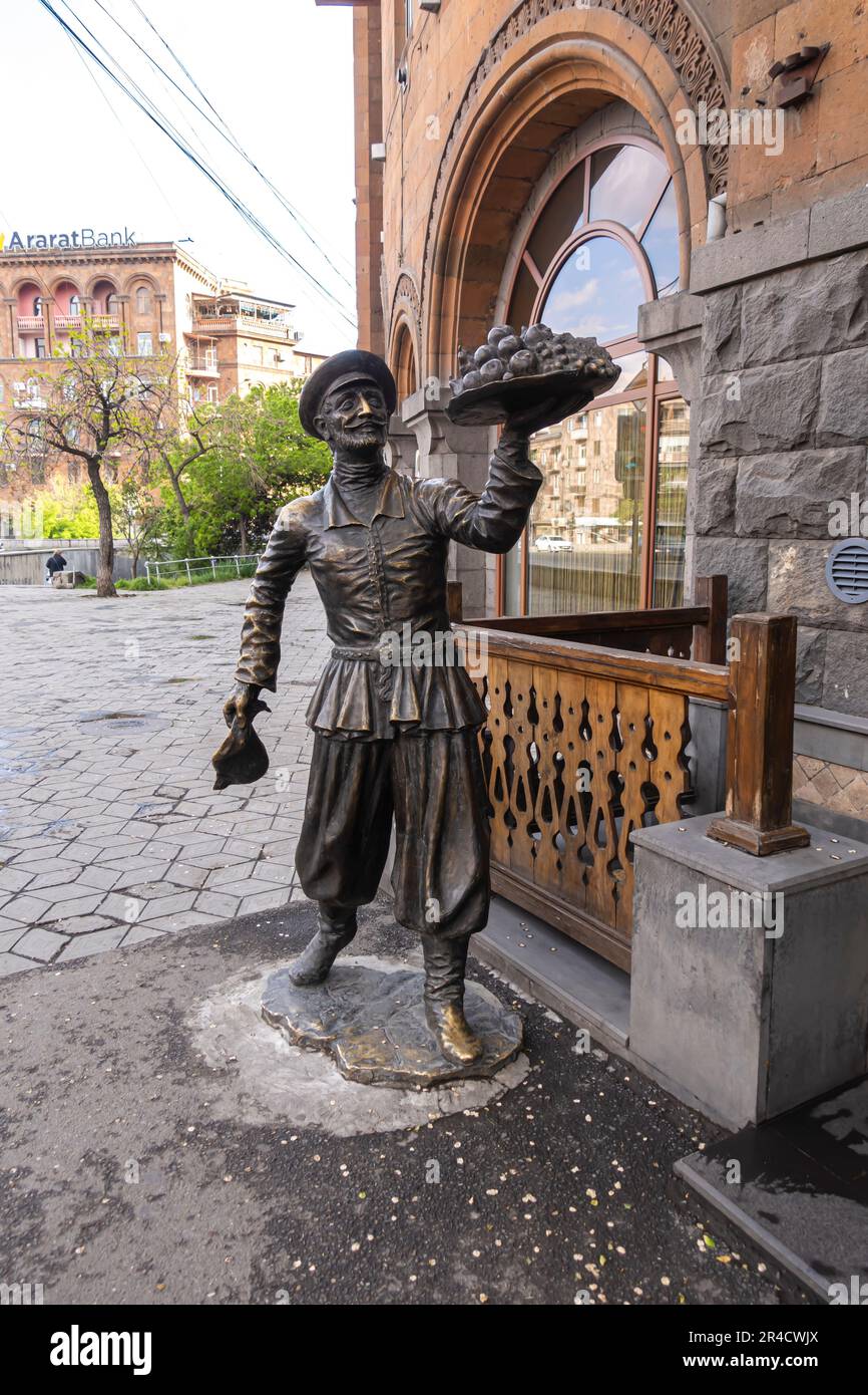 Armenian sculpture Man selling fruits pomegranades. Urban street art