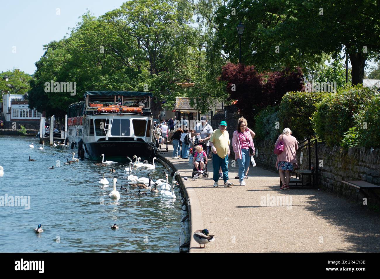 Windsor, Berkshire, UK. 27th May, 23. People walking along the Thames Path in Windsor. It was a beautiful warm and sunny day in Windsor Berkshire today as people flocked to the town for boat trips on the River Thames. Credit: Maureen McLean/Alamy Live News Stock Photo
