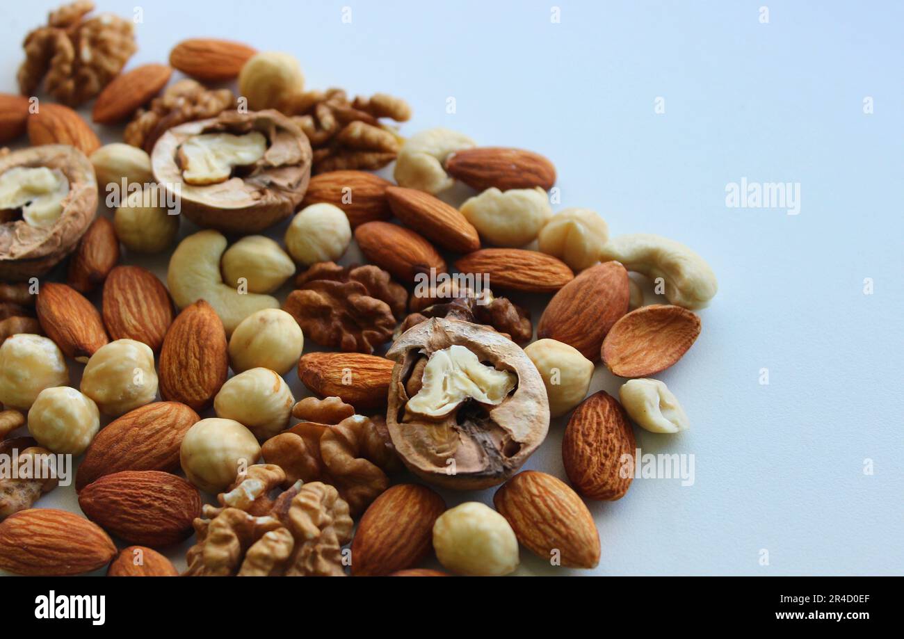 Triangle of scattered nuts of different varieties on a white background