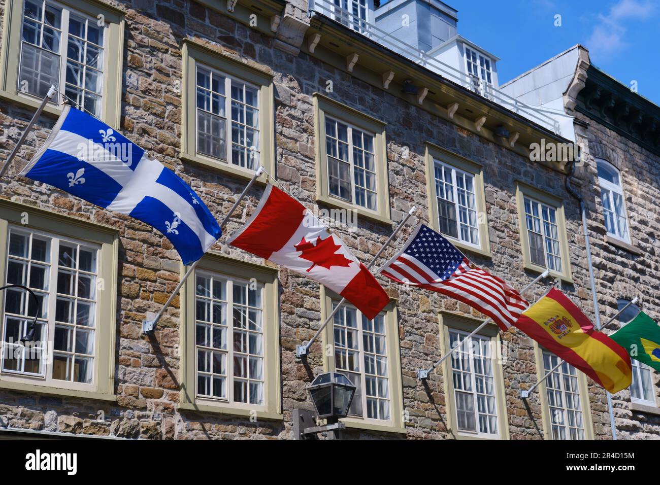 Flags of Quebec, Canada, USA and Spain outside a building in the old town, Quebec City, Canada Stock Photo