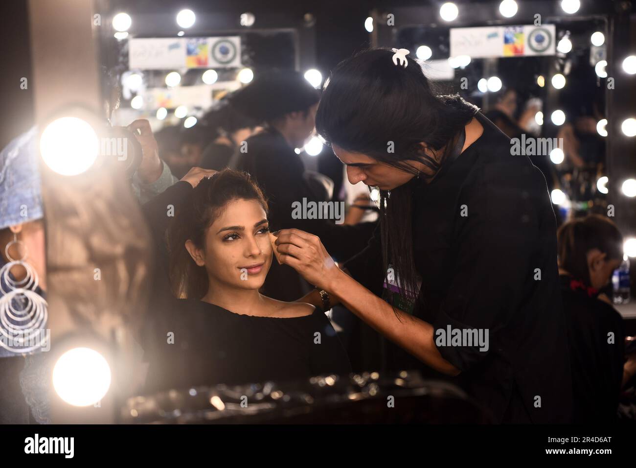 Karachi. 26th May, 2023. A makeup artist prepares a model backstage