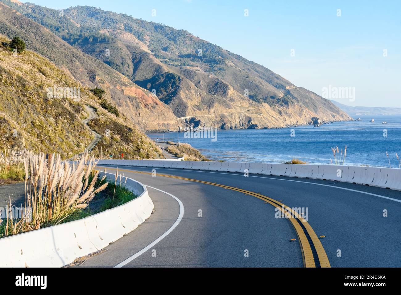 Curve along a highway running along  the rugged coast of California on a sunny autumn day Stock Photo