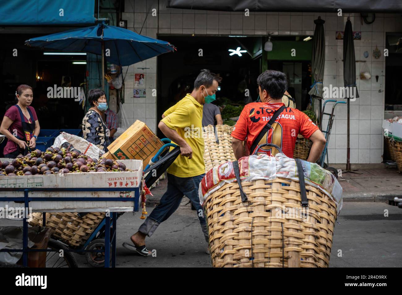 Bangkok, Thailand. 25th May, 2023. Delivery men are seen in front of one of the entrance of The Bangkok wholesale and retail Flower Market (Pak Khlong Talat) on Rattanakosin island, in Phra Nakhon district. Bangkok Flower Market (Pak Khlong Talad) Thailand's largest wholesale flower market, open 24 hours a day, 7 days a week which is adjoining a fresh vegetables, fruits and herbs market, situated on Chak Phet Road, near the Memorial Bridge (Saphan Phut) in the historic old city. (Photo by Nathalie Jamois/SOPA Images/Sipa USA) Credit: Sipa USA/Alamy Live News Stock Photo