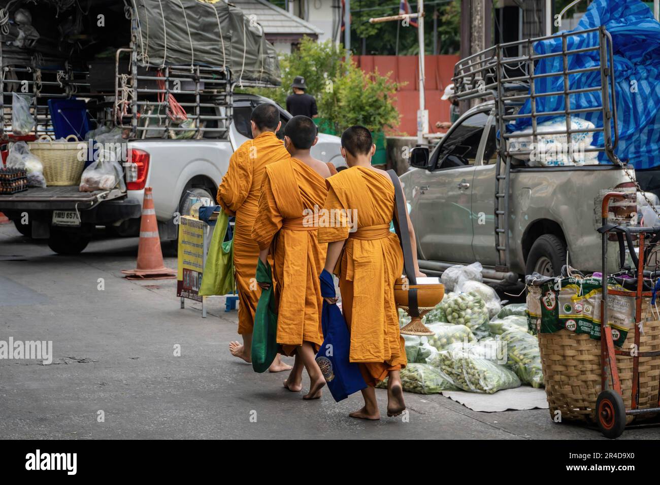 A small group of saffron-robed monks are walking with their alms bowls awaiting alms giving of food donations from the early morning local residents and business owners, all keen to make merit before the start of their day, on the adjacent road of The Bangkok Flower Market (Pak Khlong Talat). Bangkok Flower Market (Pak Khlong Talad) Thailand's largest wholesale flower market, open 24 hours a day, 7 days a week which is adjoining a fresh vegetables, fruits and herbs market, situated on Chak Phet Road, near the Memorial Bridge (Saphan Phut) in the historic old city. (Photo by Nathalie Jamois/S Stock Photo