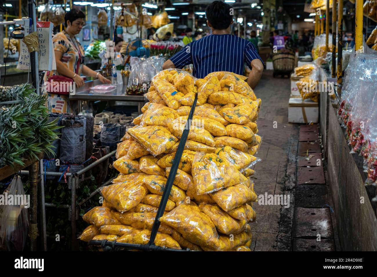 Bangkok, Thailand. 25th May, 2023. A delivery man is carrying a marigold fresh flowers order inside the narrow lanes of The Bangkok Flower Market (Pak Khlong Talat). Bangkok Flower Market (Pak Khlong Talad) Thailand's largest wholesale flower market, open 24 hours a day, 7 days a week which is adjoining a fresh vegetables, fruits and herbs market, situated on Chak Phet Road, near the Memorial Bridge (Saphan Phut) in the historic old city. (Photo by Nathalie Jamois/SOPA Images/Sipa USA) Credit: Sipa USA/Alamy Live News Stock Photo